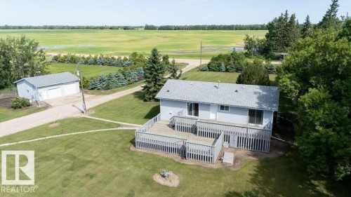 Light blue siding residence featuring a spacious wood deck - 25023 Twp Rd 612, Rural Westlock County, AB 