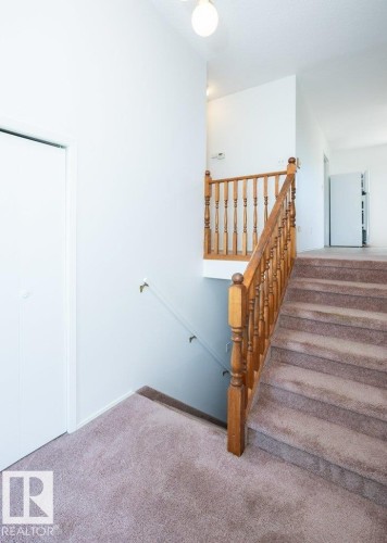 Carpeted staircase with wood banister and balusters - 25023 Twp Rd 612, Rural Westlock County, AB 