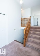 Carpeted staircase with wood banister and balusters - 