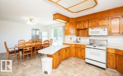 Kitchen with wood-finish cabinetry, white countertops, and a full suite of appliances - 