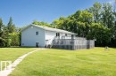 Expansive green lawn surrounds a light-colored siding home with a spacious wood deck - 25023 Twp Rd 612, Rural Westlock County, AB 