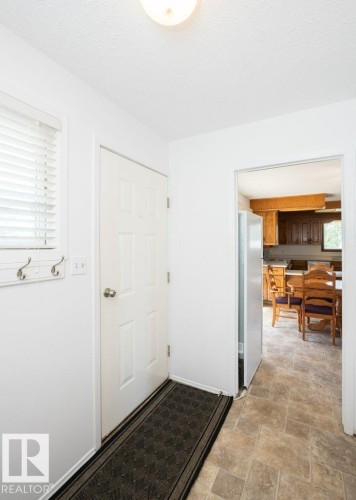 Entryway featuring neutral-toned tile flooring, a multi-paneled door, and a flush-mount ceiling light - 25023 Twp Rd 612, Rural Westlock County, AB 