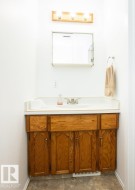 Vanity with wood-finish cabinetry, white countertop, and integrated sink - 