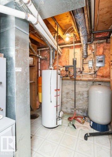 Utility space featuring a water heater, pressure tank, and exposed ceiling joists - 25023 Twp Rd 612, Rural Westlock County, AB 