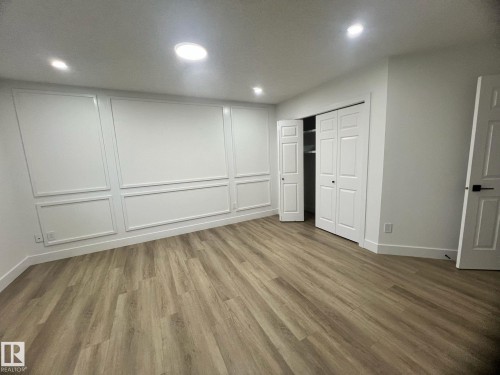 Spacious room featuring wood-finish flooring and recessed lighting - 3320 43 Street, Edmonton, AB 