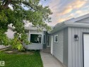 Contemporary home with mixed siding, featuring a prominent bay window, attached garage, and sleek exterior lighting - 3320 43 Street, Edmonton, AB 