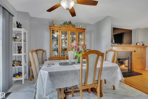 Dining area featuring white marble-look tile flooring and a ceiling fan with integrated lighting - 184 Garwood Cres, Wetaskiwin, AB - Indoor Photo Showing Dining Room With Fireplace