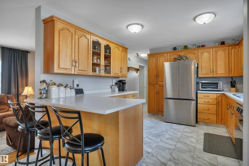 Kitchen featuring light wood cabinetry, light countertops, and a stainless steel refrigerator - 184 Garwood Cres, Wetaskiwin, AB - Indoor Photo Showing Kitchen