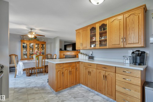 Kitchen featuring wood-finish cabinetry, white countertops, and marble-patterned floor tiles - 184 Garwood Cres, Wetaskiwin, AB - Indoor Photo Showing Kitchen