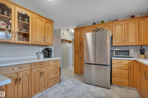 Kitchen featuring light wood cabinetry, a stainless steel French door refrigerator, white countertops, and light-toned tile flooring - 184 Garwood Cres, Wetaskiwin, AB - Indoor Photo Showing Kitchen