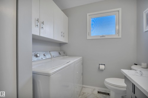 Laundry area featuring white cabinetry with silver hardware, a single window, and marble-look flooring - 184 Garwood Cres, Wetaskiwin, AB - Indoor Photo Showing Other Room