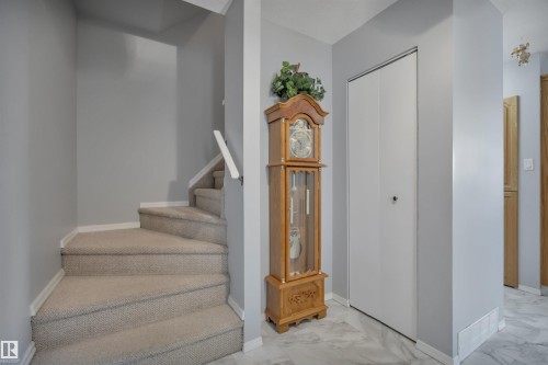 Carpeted staircase with white handrail and baseboards, complemented by a white bi-fold closet door - 184 Garwood Cres, Wetaskiwin, AB - Indoor Photo Showing Other Room