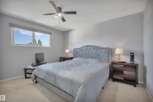 Bright interior space featuring a window with a roller shade, light-toned carpeting, and a ceiling fan with integrated lighting - 184 Garwood Cres, Wetaskiwin, AB - Indoor Photo Showing Bedroom