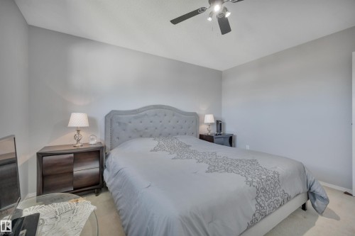 Carpeted bedroom featuring a tufted upholstered headboard, a ceiling fan with integrated lighting, and neutral wall tones - 184 Garwood Cres, Wetaskiwin, AB - Indoor Photo Showing Bedroom