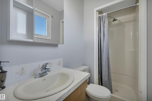 Bathroom featuring a single-basin vanity with a laminate countertop, chrome fixtures, and a medicine cabinet with a mirrored front - 184 Garwood Cres, Wetaskiwin, AB - Indoor Photo Showing Bathroom