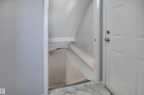 White panel door with polished chrome hardware, white trim, and a marble-look tile threshold - 184 Garwood Cres, Wetaskiwin, AB - Indoor Photo Showing Other Room