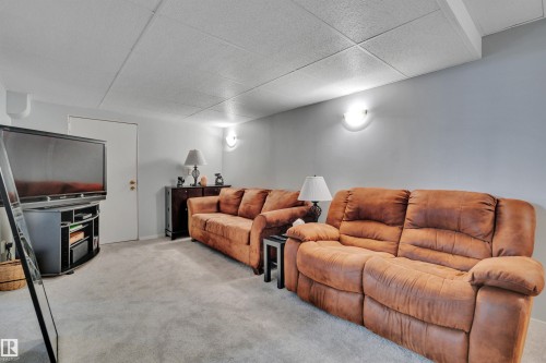 Carpeted recreation room featuring light gray walls and a grid-patterned ceiling - 184 Garwood Cres, Wetaskiwin, AB - Indoor