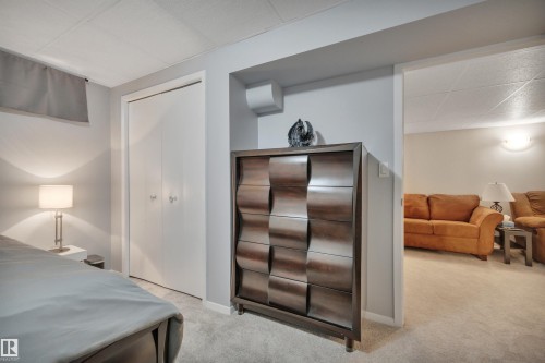 Carpeted interior space featuring a bi-fold closet, recessed ceiling, and a wall cutout revealing an additional room - 184 Garwood Cres, Wetaskiwin, AB - Indoor Photo Showing Other Room
