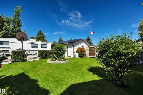Manicured lawn with mature landscaping and a well-maintained garden bed - 184 Garwood Cres, Wetaskiwin, AB - Outdoor
