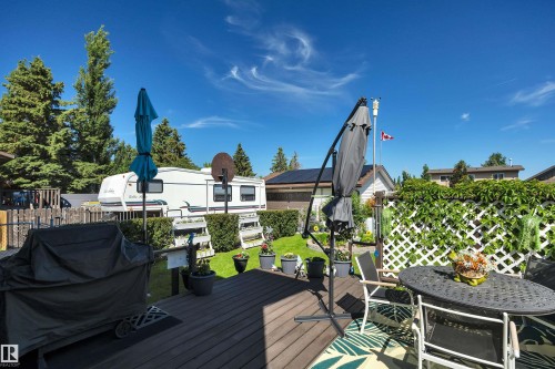 Composite wood-finish deck with a white lattice privacy screen and mature perimeter trees - 184 Garwood Cres, Wetaskiwin, AB - Outdoor With Deck Patio Veranda
