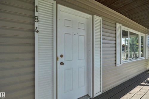 Entryway featuring a white paneled door with brass hardware, flanked by decorative white louvered shutters and house numbers - 184 Garwood Cres, Wetaskiwin, AB - Outdoor With Exterior