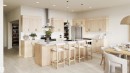 Open-concept kitchen featuring light wood-finish cabinetry, stainless steel appliances, a large island with seating, pendant lighting, and light-tone wood-finish flooring - 1729 Crossbill Loop N, Edmonton, AB 