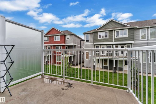 Private concrete balcony with white metal railing and translucent privacy panel - 82 1816 Rutherford Road, Edmonton, AB 