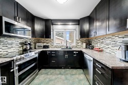 U-shaped kitchen featuring dark wood-finish cabinetry, a stainless steel over-the-range microwave, and a stainless steel electric range - 