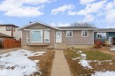 Ranch-style residence featuring neutral-toned horizontal siding and a prominent bay window - 5418 17A Avenue, Edmonton, AB 