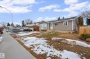 Ranch-style residence featuring grey horizontal siding and a dark shingle roof - 5418 17A Avenue, Edmonton, AB 