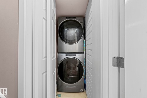 Dedicated laundry closet featuring a stacked washer and dryer, providing functional utility within the home - 5418 17A Avenue, Edmonton, AB 