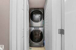 Dedicated laundry closet featuring a stacked washer and dryer, providing functional utility within the home - 