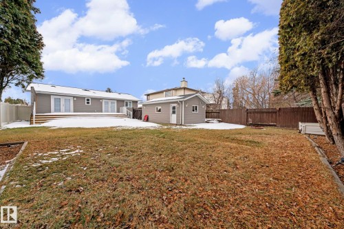Spacious backyard with a detached shed, a full privacy fence, and a multi-level deck featuring multiple sets of double doors - 5418 17A Avenue, Edmonton, AB 