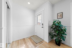 Entryway featuring a decorative glass panel door, recessed ceiling lighting, light wood-finish flooring, and wainscoting - 