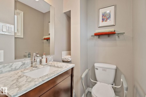 Bathroom featuring a single vanity with a stone countertop, an undermount sink, and a chrome faucet - 10715 33 Avenue, Edmonton, AB 