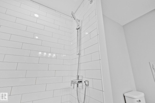 Shower with horizontal white subway tile, recessed lighting, and chrome fixtures - 10715 33 Avenue, Edmonton, AB 