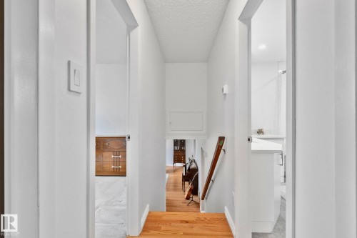 Hallway with light wood-finish flooring and white walls - 10715 33 Avenue, Edmonton, AB 