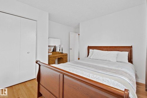 Light wood-finish flooring complements the white walls and bi-fold closet doors - 10715 33 Avenue, Edmonton, AB 