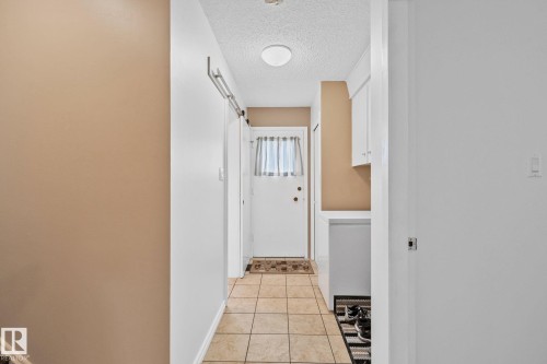 Foyer featuring neutral-toned tile flooring, light-colored walls, and a recessed ceiling light - 10715 33 Avenue, Edmonton, AB 