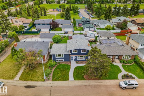 Two-story residence featuring a dark blue exterior with white trim, a gabled roof, and an attached garage - 10715 33 Avenue, Edmonton, AB 