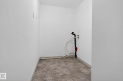 Utility room featuring a tiled floor, white walls, and plumbing connections for appliances - 