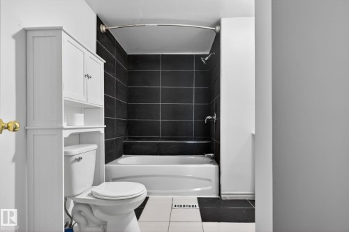 Full bathroom featuring a white bathtub with a black tiled shower surround - 543 Evergreen Street, Edmonton, AB 