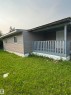Property exterior featuring gray horizontal siding and a covered front porch with a wood railing - 543 Evergreen Street, Edmonton, AB 