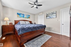 Bedroom featuring rich wood-finish flooring, a ceiling fan, and light-toned wall paint - 