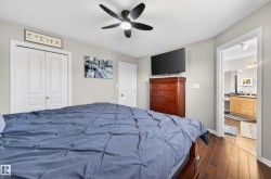 Bedroom featuring wood-finish flooring, a ceiling fan with integrated lighting, and a white paneled closet - 