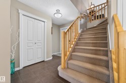 Carpeted staircase with light wood banister and spindles - 