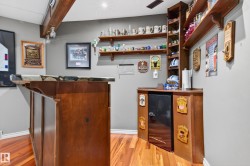 Custom built-in bar featuring a stone-finish countertop, wood-finish cabinetry, and integrated mini-refrigerator - 