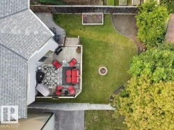 Spacious backyard featuring a multi-level wood deck, a circular fire pit, and a manicured lawn - 