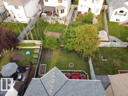 Expansive backyard with a manicured lawn, established trees, and multiple distinct patio areas - 