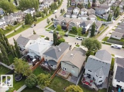 Aerial view showcasing multiple residential properties with varied rooflines and exterior finishes - 